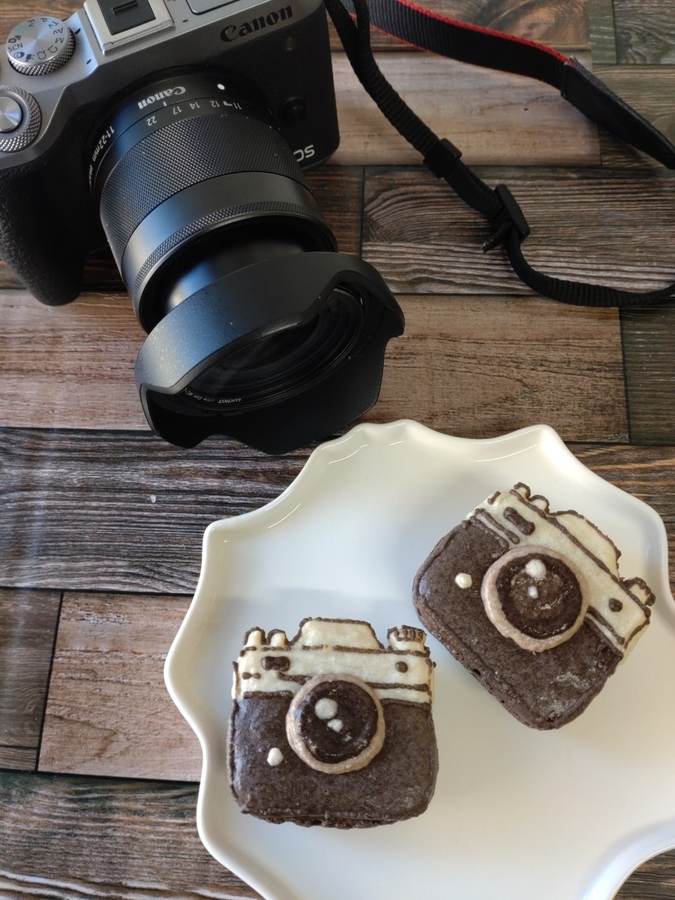 うちの一眼カメラ(Canon EOS M6 Mark II)と広角ズームレンズ。カメラ型のマカロンと一緒に撮影。
