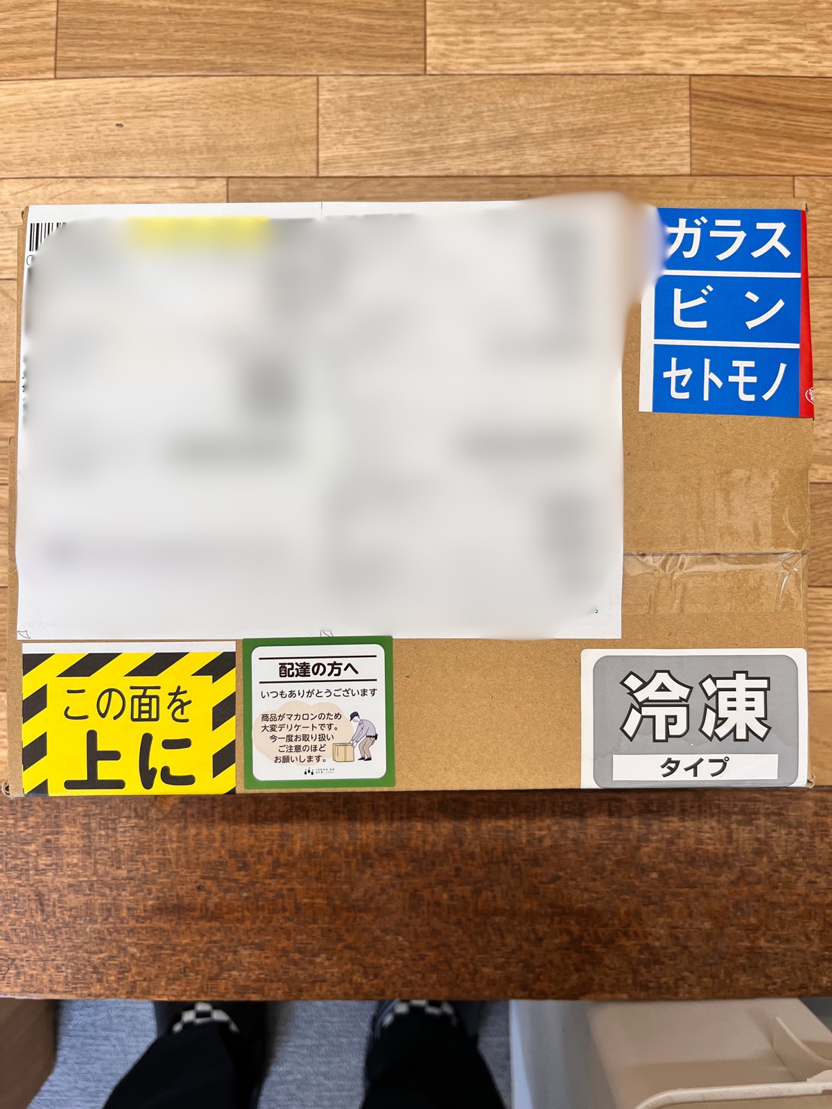 冷凍便で発送するお菓子の箱。ガラス・ビン・セトモノのシール、この面を上にのシール、配達の方へのオリジナルシール、冷凍タイプのシールが貼られている。