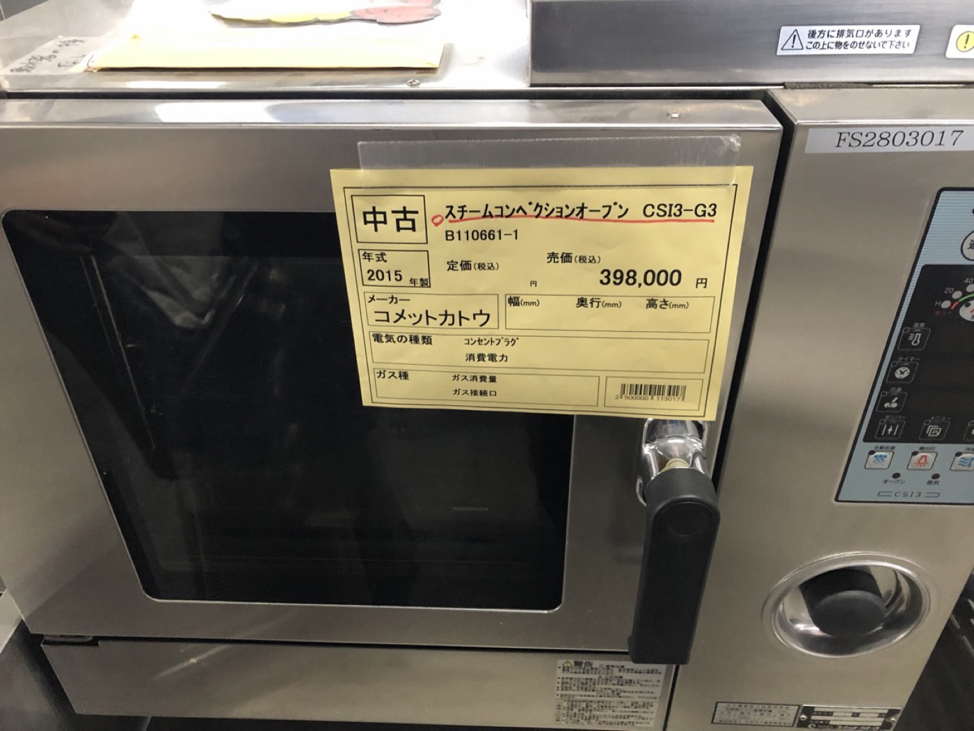 中古厨房機器店のスチームコンベクションオーブンに貼られた値札。コメットカトウ製CSI3-G3、2015年製、売価398,000円と印字されている。