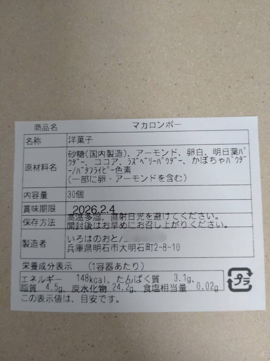 ブラザーQL-820NWBで印刷した食品表示シールの拡大写真。商品名マカロンポー、名称洋菓子、原材料名、内容量30個、賞味期限、保存方法、製造者、栄養成分表示の全項目が黒い文字で読める。