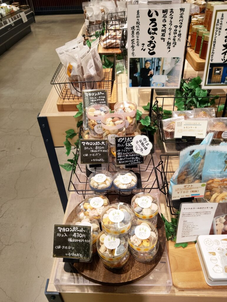 スーパーの売り場に並ぶ、いろはのおとの焼き菓子。手書きの値札と、店を紹介するポップ。