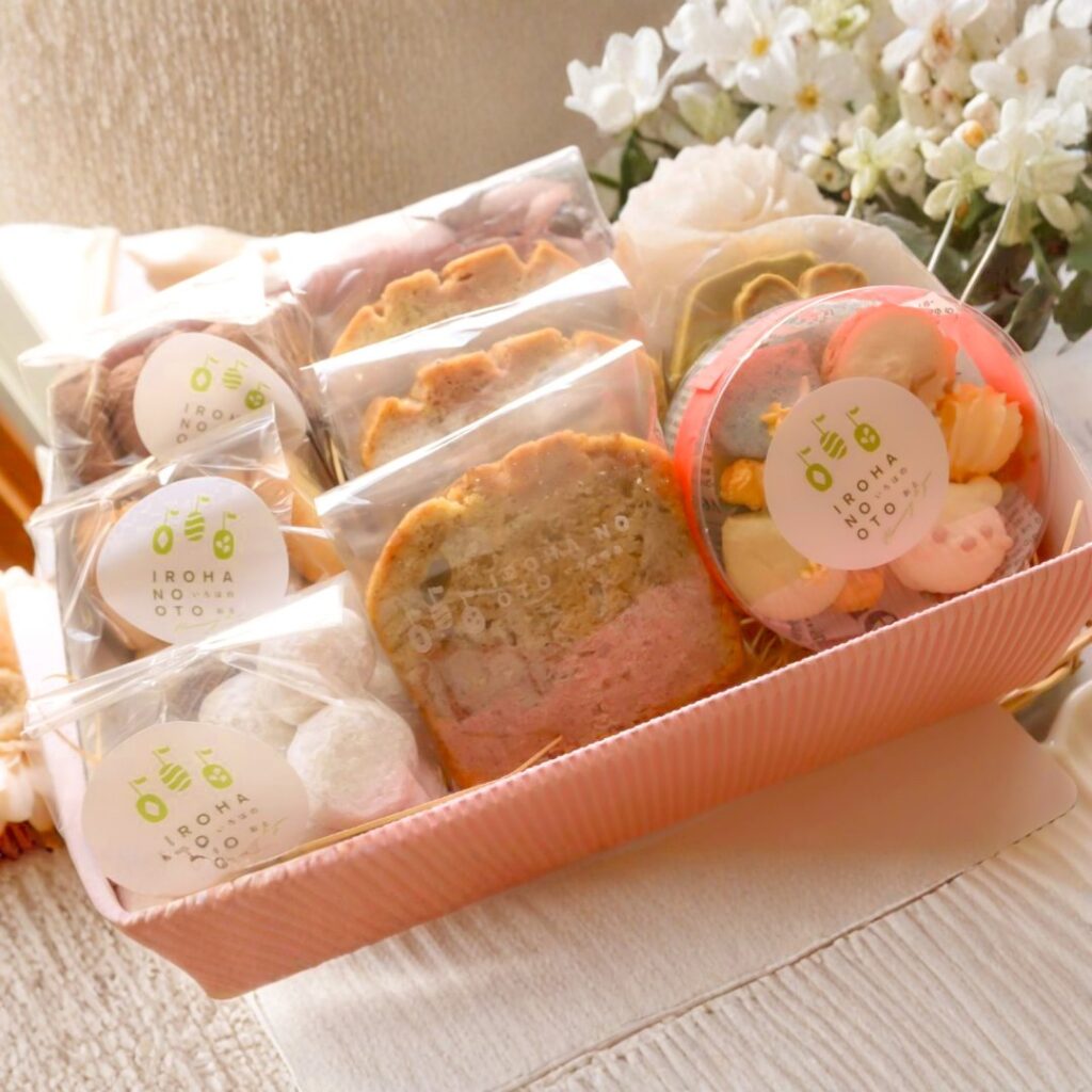 ピンクのギフトボックスに、個包装した焼き菓子を立てて詰めたお供えセット（小）。