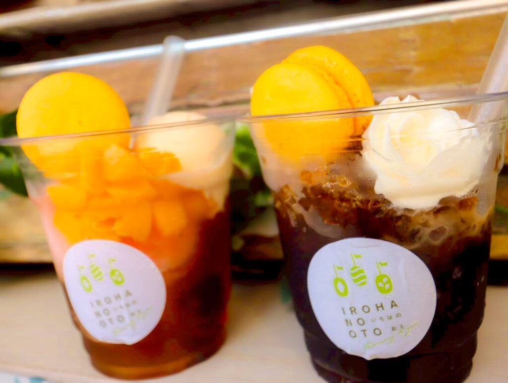 いろはのおとの夏向けの冷たいスイーツ。カップに入ったゼリーやクリームの上に、黄色いマカロンをのせたもの。
